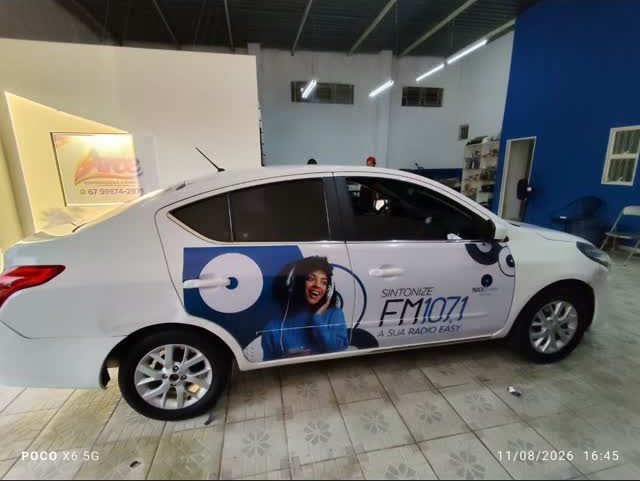 Veículo da emissora dentro da oficina, com a plotagem sendo aplicada.